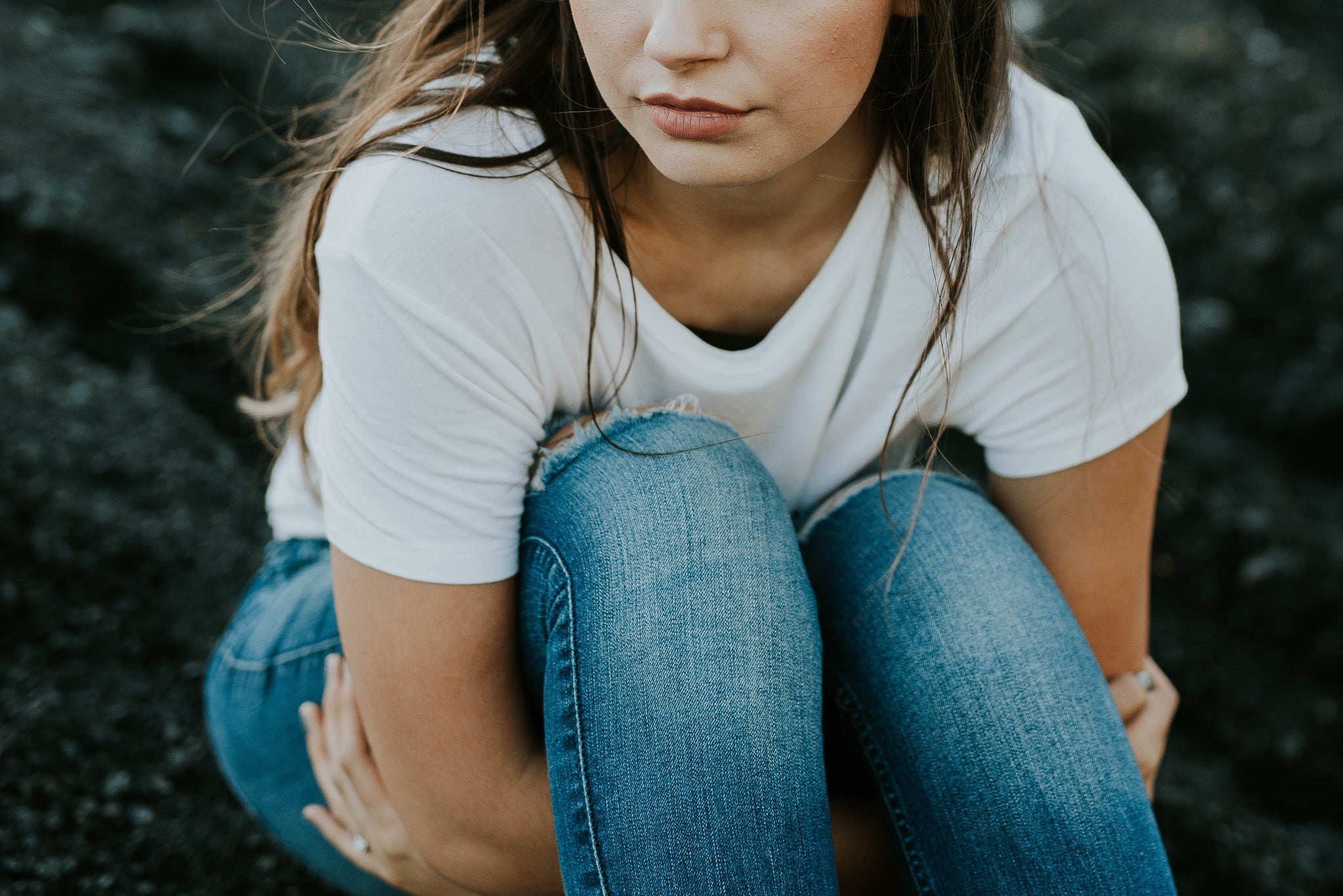 How Unplanned Pregnancy Can Affect Your Sex Life. The image is of a woman with fair skin, hugging her legs into her chest.