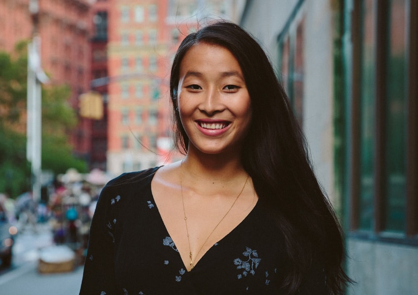 Nadya Okamoto, standing and smiling at the camera